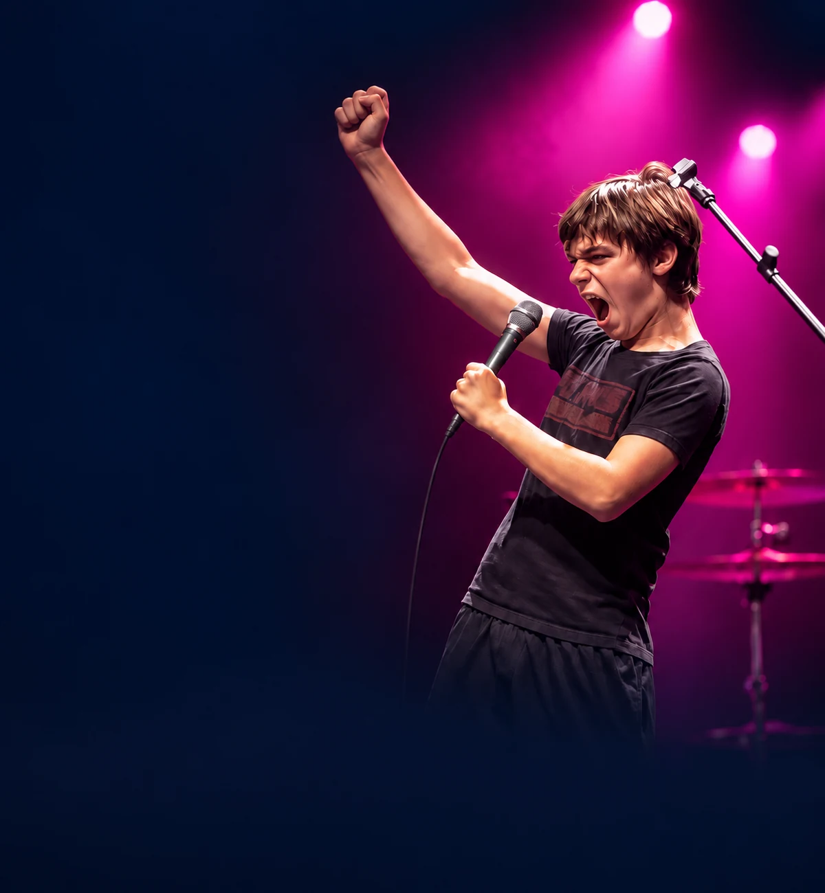 A young BLE singer reaching for the lights on stage