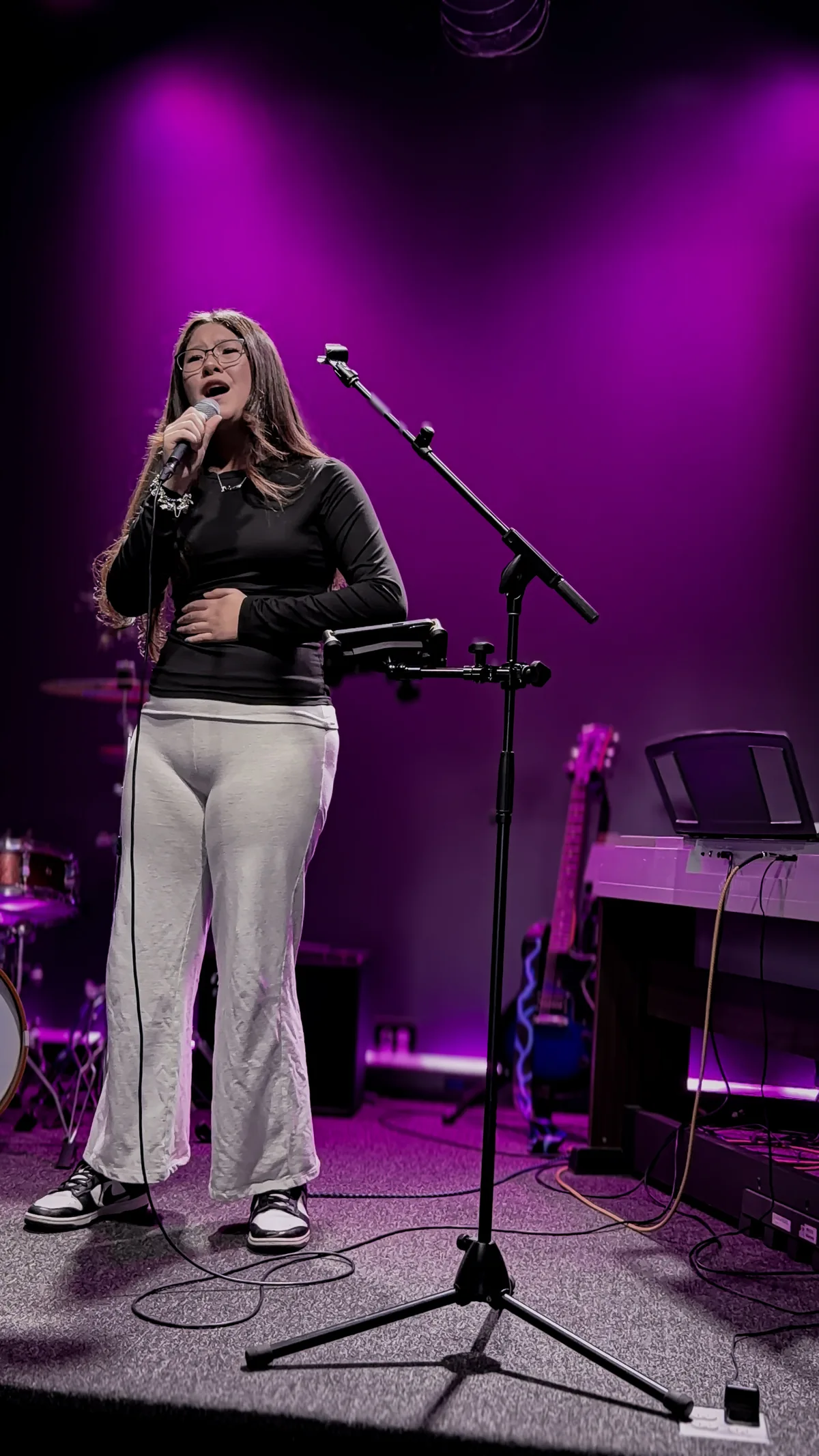 A BLE singer sharing her song on the magenta-lit stage